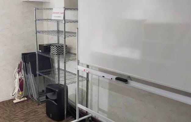 スタジオ内の収納スペース。椅子やホワイトボードなどが整理され、必要な設備が揃っています。
