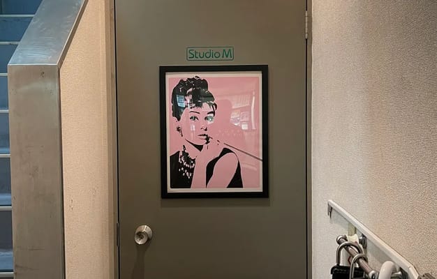 オードリー・ヘプバーンのポスターが掲げられたドアが特徴的なスタジオ入口の様子。