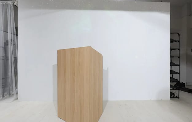 シンプルなプレゼンテーションエリア。木製の演壇と白い壁を背景に、プロジェクターを使用した発表やセミナーにも適した空間。